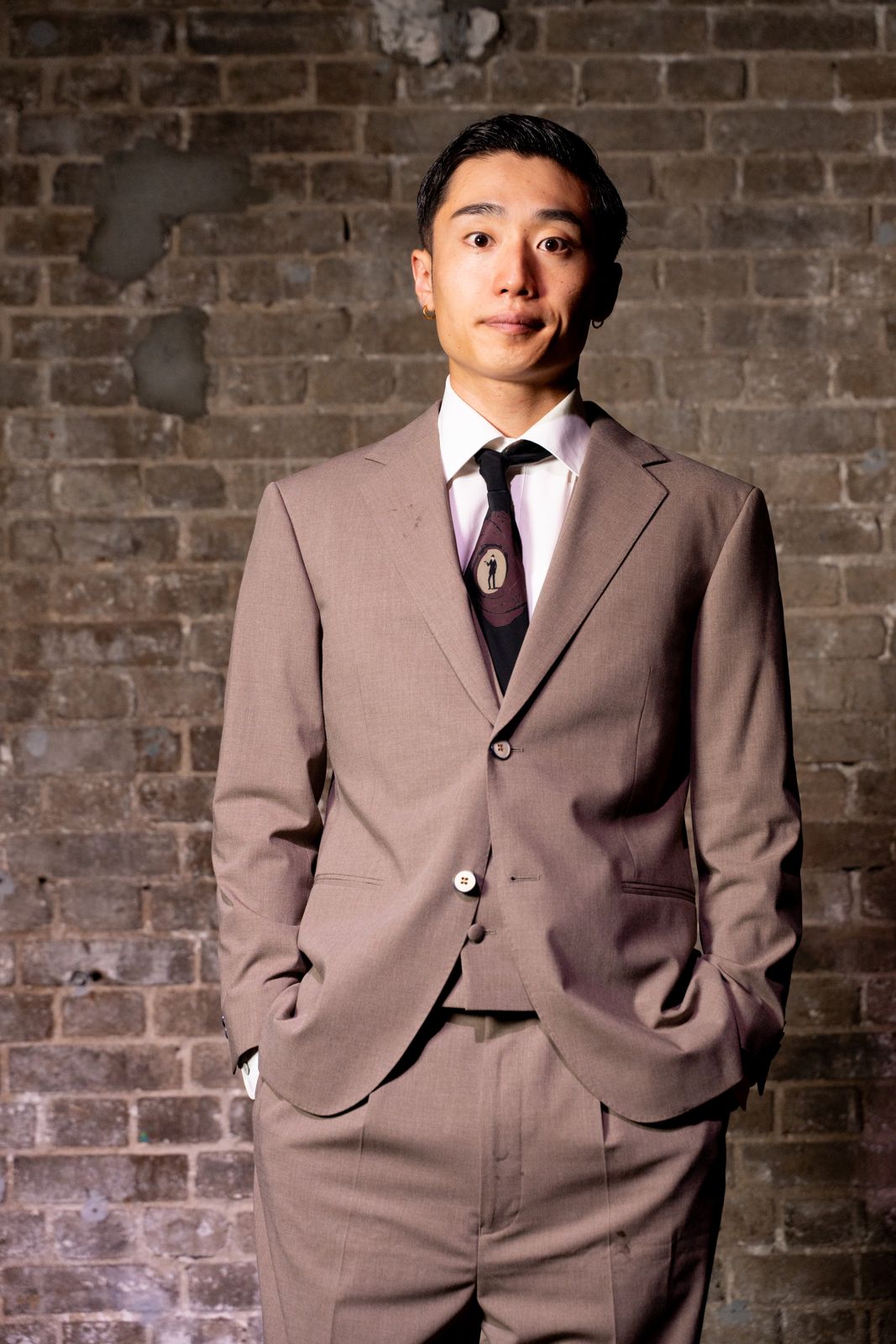 ベージュのスーツで立つKO→TARO